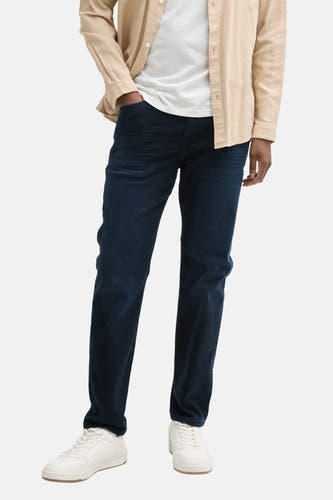 Jean tapered en denim bleu et noir de Tom Tailor, vu de derrière, associé à un T-shirt blanc et des chaussures blanches.