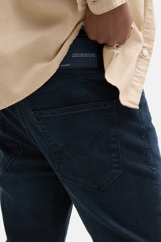Jean tapered bleu marine de TOM TAILOR, avec une poche arrière et un étiquette en cuir.