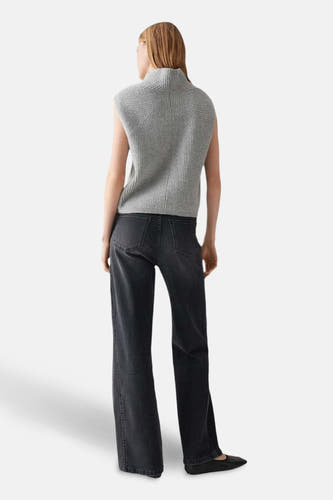 Sweat-shirt gris tréssé d'OPUS, avec un col haut et associé à des jeans foncés et des chaussures plates.