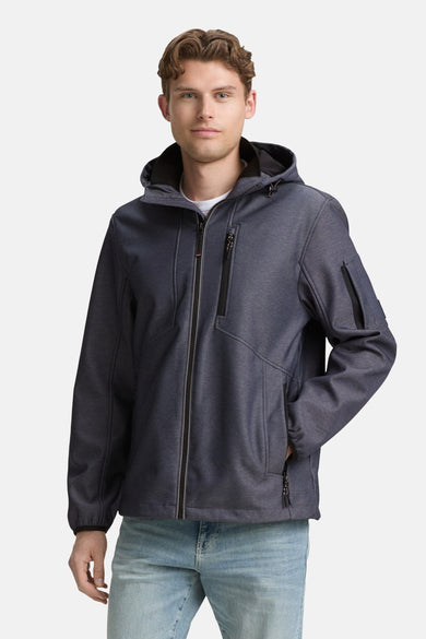 Manteau bleu court de TOM TAILOR, avec capuche et poches à fermeture éclair, porté avec un pantalon en cuir.