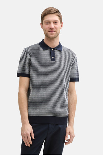 Blauw poloshirt van TOM TAILOR met een fijn grafisch dessin, gedragen met een donkere broek.
