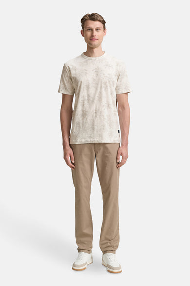 Ecru T-shirt met korte mouwen van TOM TAILOR, met palmmotief, gecombineerd met bruine broek en witte sneakers.
