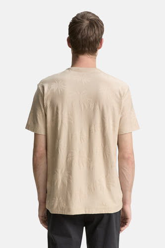 Beige T-shirt met korte mouwen van TOM TAILOR, met palmboomreliëf op de rug, gedragen met een donkere broek.