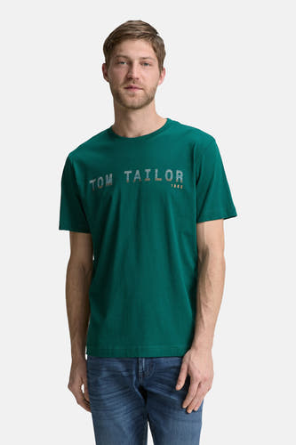 T-shirt vert avec manches courtes de Tom Tailor, imprimé et porté avec un jean bleu.