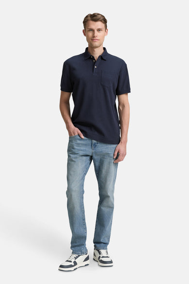 T-shirt bleu de manches courtes de TOM TAILOR, avec une poche devant et porté avec des jeans et des baskets.