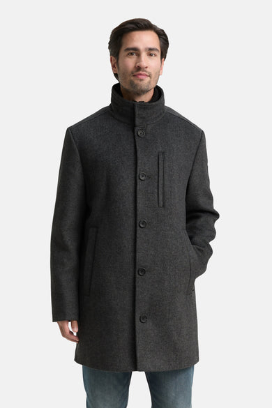 Manteau gris long de TOM TAILOR, avec fermeture à boutons et poches, porté sur une chemise sombre et des jeans.