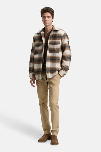 Manteau court brun de TOM TAILOR, avec un motif à carreaux, porté avec un t-shirt brun et des pantalons kaki et des chaussures.