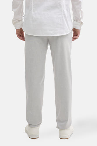 Chino gris de TOM TAILOR, vu de de derrière, avec une subtile texture et associé à un chemisier blanc.