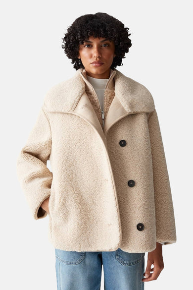 Manteau court beige d'OPUS, avec doublure et longues manches, vu de derrière.
