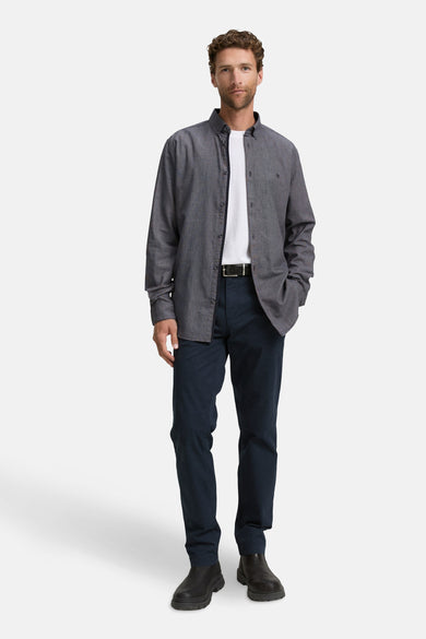 Chemise bleue à manches longues de TOM TAILOR, portée sur un t-shirt blanc, avec des pantalons foncés et des chaussures noires.