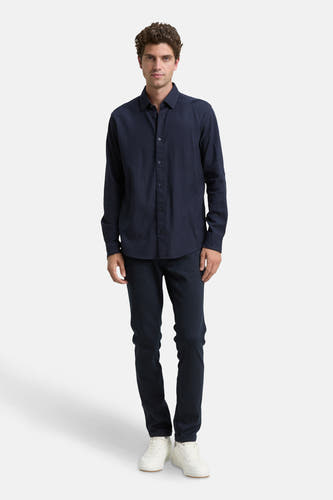Chemise bleue à manches longues de TOM TAILOR, portée avec un pantalon foncé et des chaussures blanches.