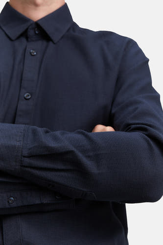 Chemise bleue à manches longues de TOM TAILOR, avec une fine texture et des bras croisés.