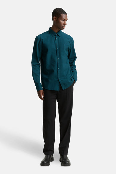Chemise turquoise à manches longues de TOM TAILOR, portée avec un pantalon noir et des chaussures noires.