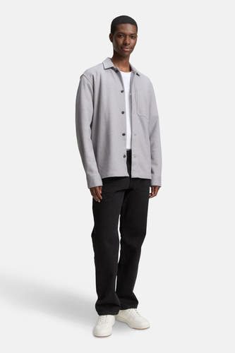 Chemise grise de TOM TAILOR, avec col boutonné, poche poitrine et portée sur un T-shirt blanc avec des jeans noirs.