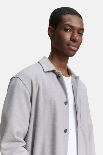 Chemise grise de TOM TAILOR, à col boutonné et avec une poche poitrine, portée sur un t-shirt blanc.