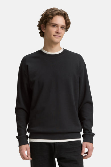 Gilet noir avec col rond de TOM TAILOR, porté sur un t-shirt blanc.