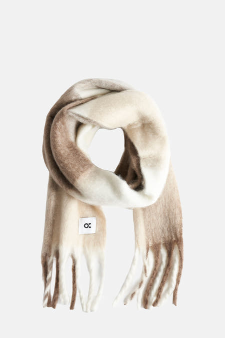 Châle d'hiver multicolore d'OPUS, enroulé en spirale avec différentes teintes brunes et blanches.