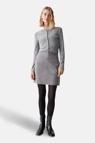Korte grijze rok van OPUS, gedragen met zwarte panty en enkellaarsjes.
