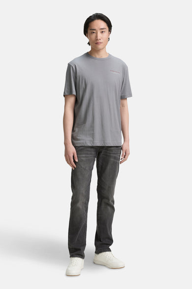 T-shirt gris à manches courtes de TOM TAILOR, associé à des jeans foncés et des baskets blanches.