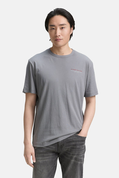 T-shirt gris à manches courtes de Tom Tailor, avec un petit imprimé texte rouge et un pantalon denim décontracté.