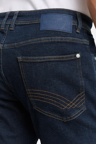 Jean slim de denim bleu marine de TOM TAILOR, avec une poche arrière et des surures jaunes foncées.