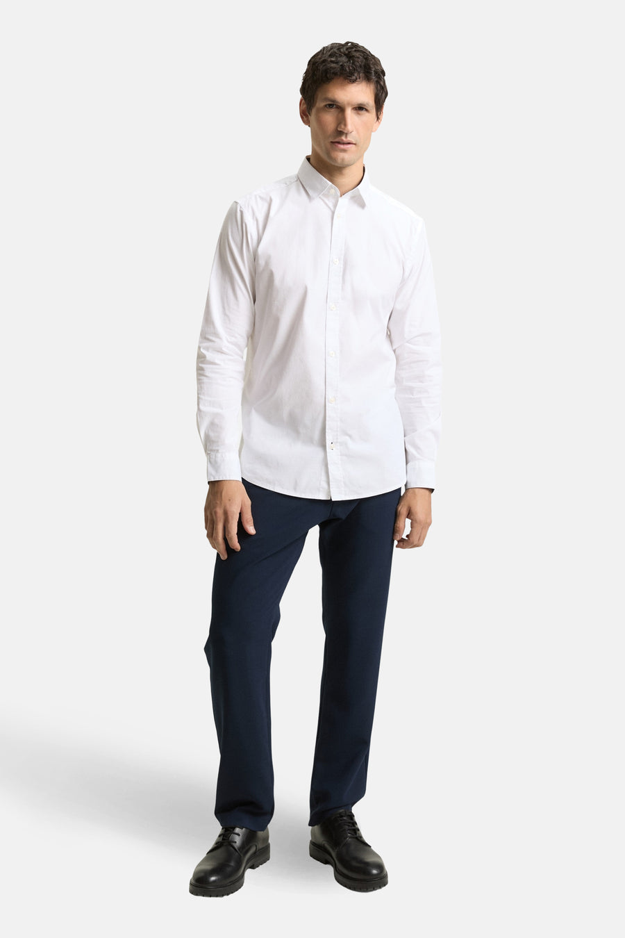 Wit overhemd met lange mouwen van TOM TAILOR, gecombineerd met donkerblauwe pantalon en zwarte schoenen.