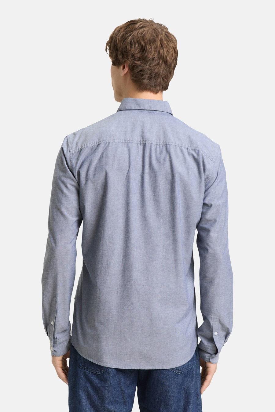 Man met blauw overhemd van achteren gezien.