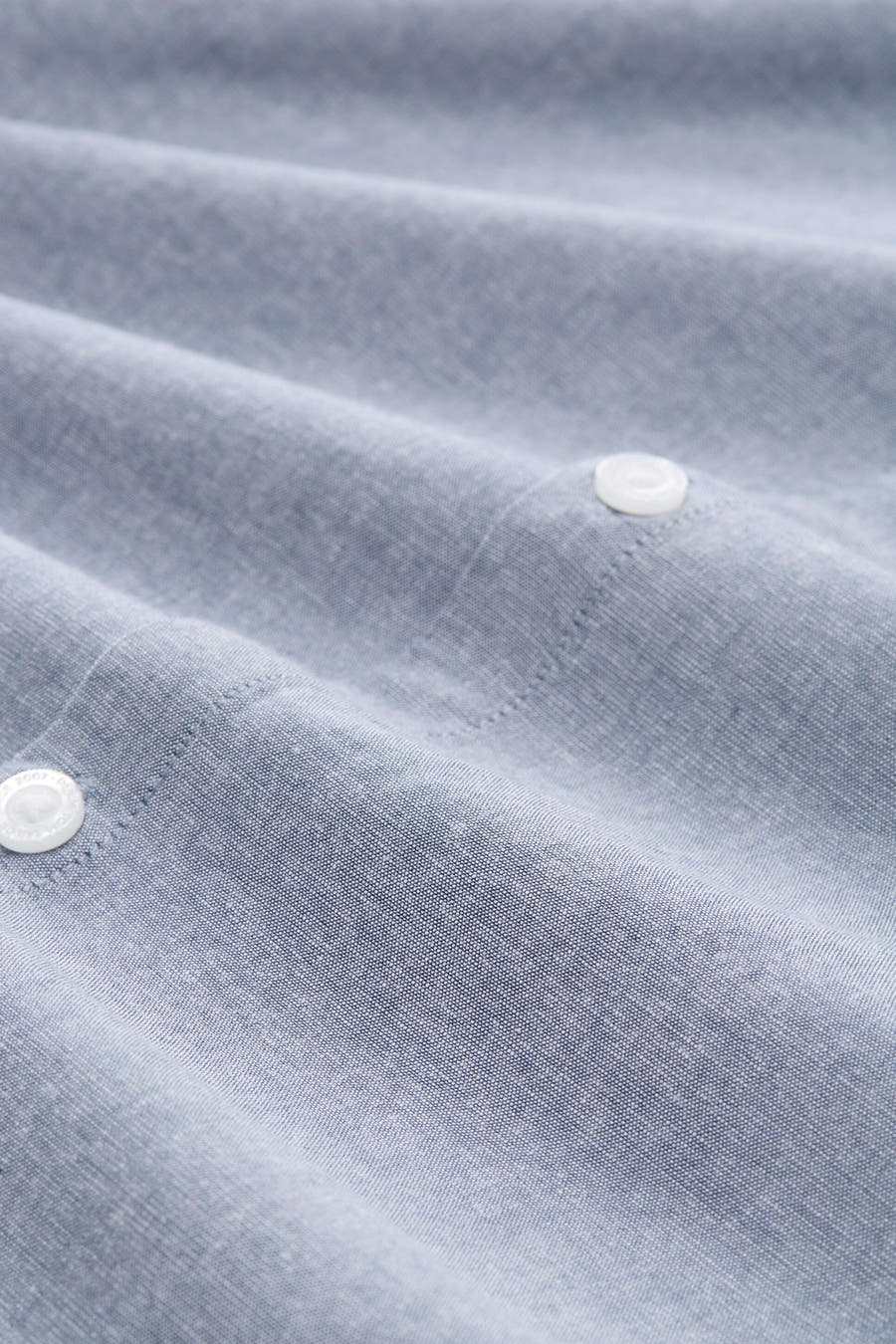 Chemise bleue à manches longues de TOM TAILOR, avec des plis subtils et des boutons blancs.