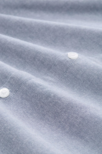 Lichtblauw overhemd met witte knopen.