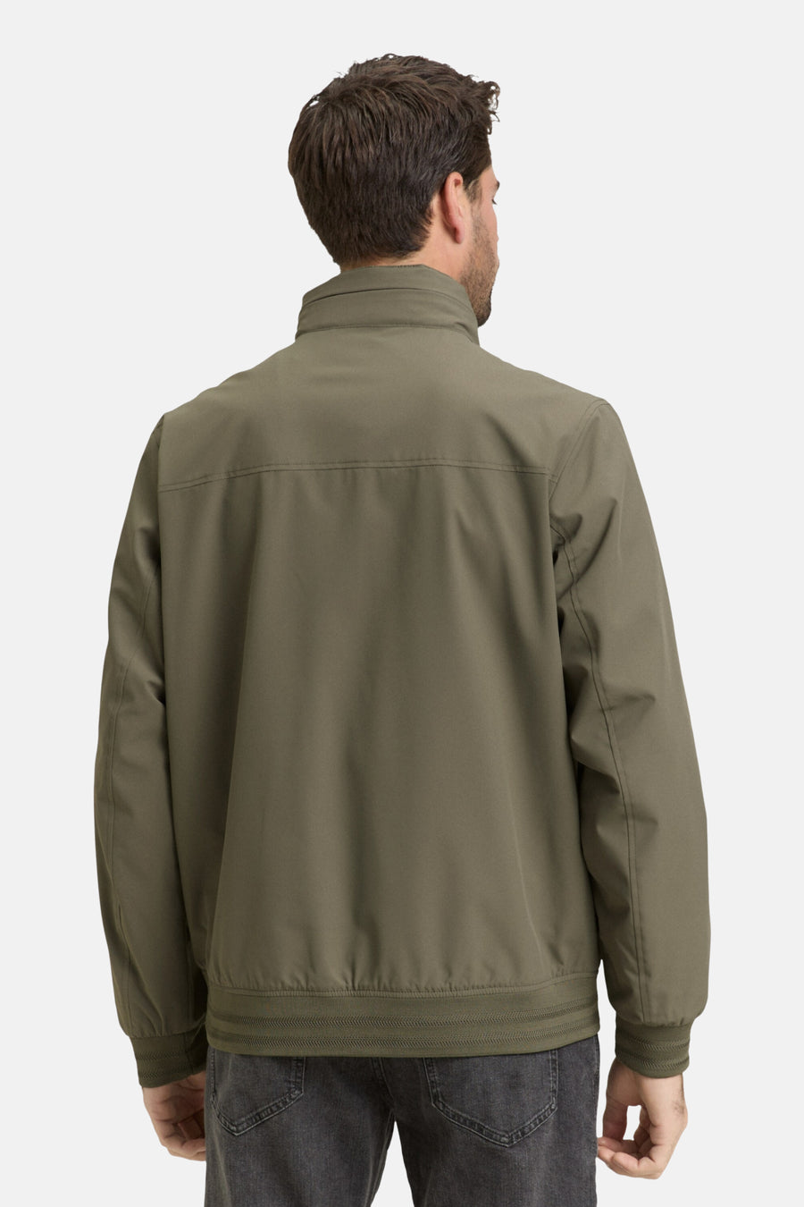 Achterkant van een man in een olijfgroen jack.