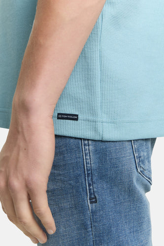 Blauw wafelstructuur shirt met logo, blauwe jeans.