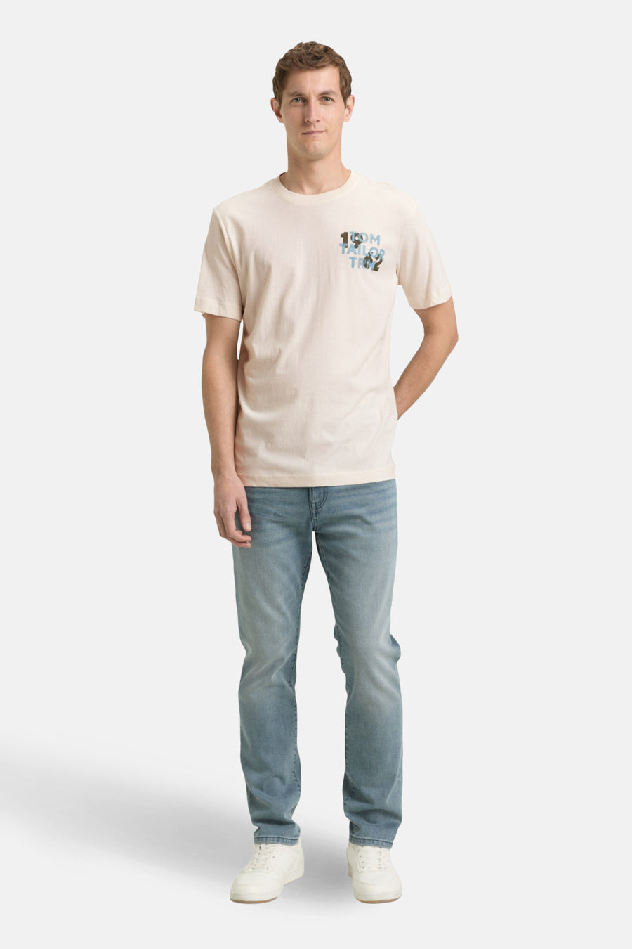 Ecru T-shirt met korte mouwen van TOM TAILOR, met een kleine blauwe print linksboven, gecombineerd met een jeans en witte sneakers.
