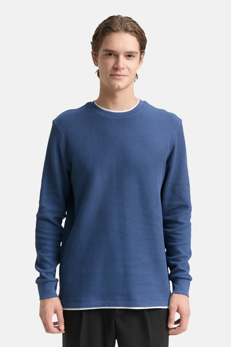 Man met een blauw, geribbeld shirt.