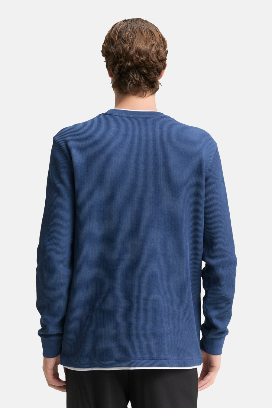 Achterkant van een blauwe trui met lange mouwen.
