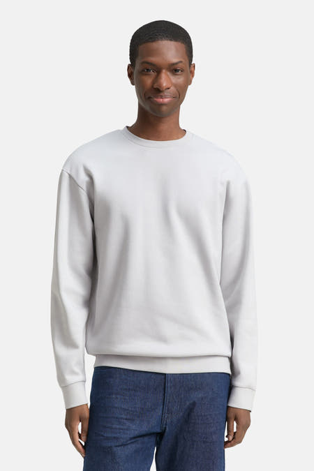 Pull gris de TOM TAILOR, avec des manches longues, associé à des jeans foncés et des baskets blanches.