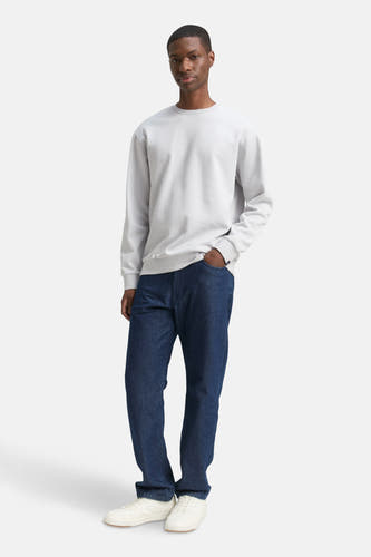Grijze sweater van TOM TAILOR, met lange mouwen, gecombineerd met donkere jeans en witte sneakers.