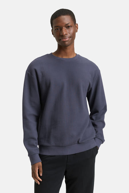 Pull-over bleu avec col rond de TOM TAILOR, associé à un pantalon noir et des baskets blanches.