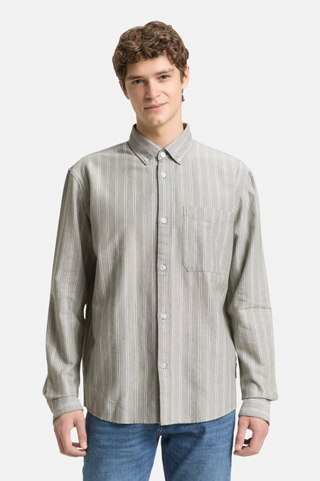 Man in gestreept overhemd, blauwe jeans.
