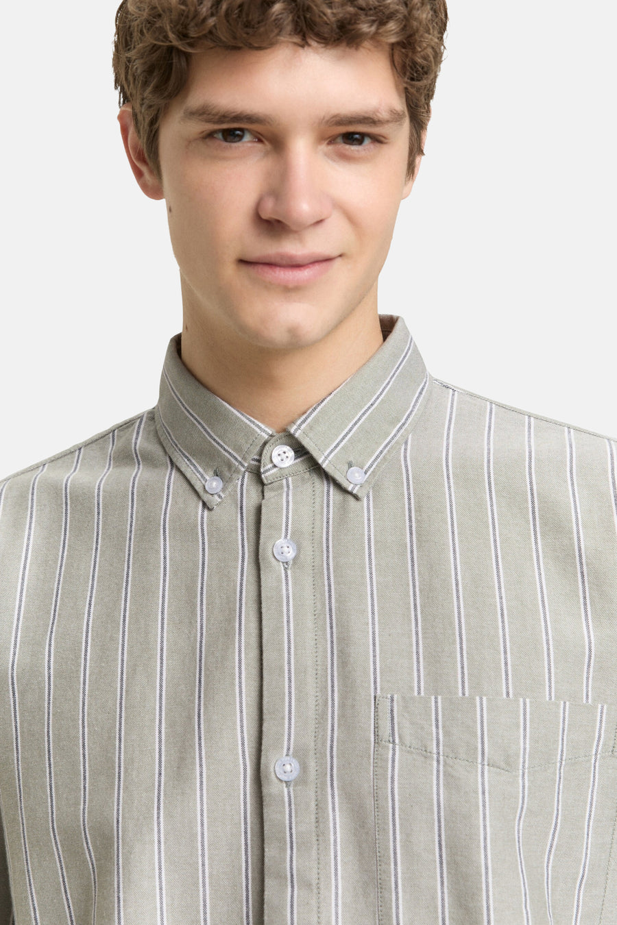 Jonge man met een gestreept overhemd in kaki.