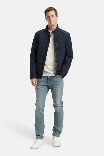 Korte blauwe jas van TOM TAILOR, met een ruitpatroon en gedragen met een wit T-shirt en lichte jeans.