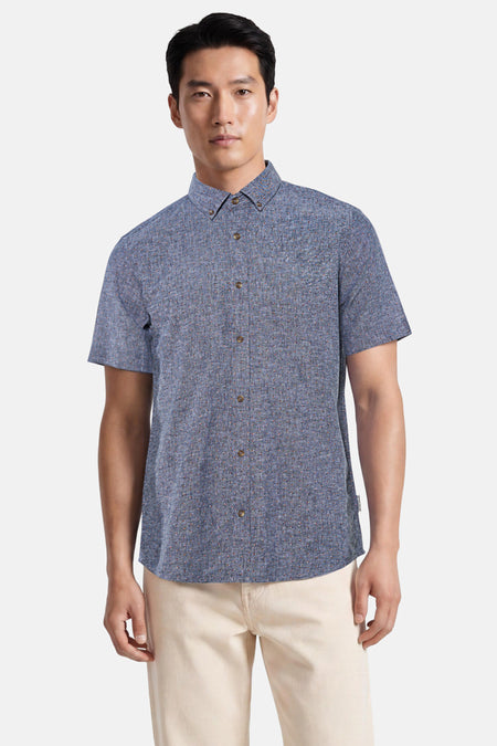 Chemise bleue à manches courtes de TOM TAILOR, avec motif à petits carreaux et boutons marron, portée par un homme.