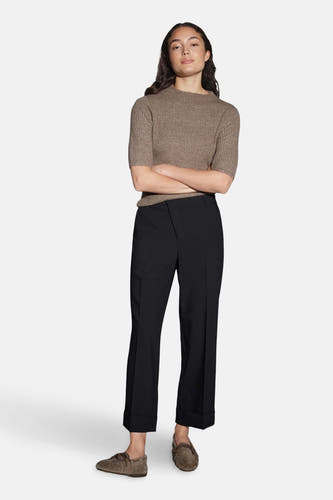 Zwarte broek van OPUS, met een hoge taille en omgeslagen pijpen, gecombineerd met een bruine gebreide top en suède mocassins.
