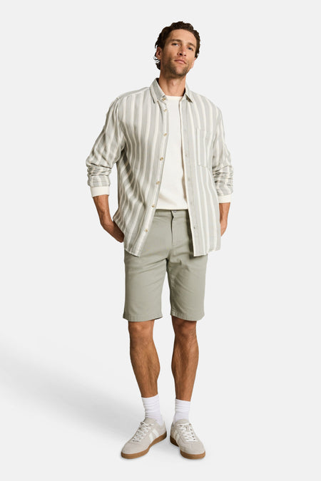 Groene shorts van TOM TAILOR, gedragen door een man met een gestreept overhemd en lichte sneakers.