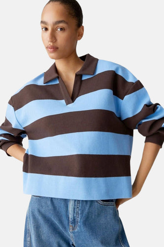 Vrouw met gestreepte trui en jeans op een witte achtergrond.