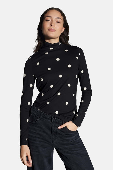 T-shirt noir à manches longues d'OPUS, avec des taches blanches et porté avec un pantalon noir.