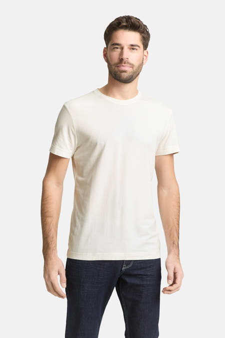 T-shirt blanc à manches courtes de TOM TAILOR, porté sous un gilet bleu marine zippé et un jean foncé.