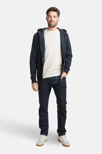 Wit T-shirt met korte mouwen van TOM TAILOR, gedragen onder een marineblauw vest met rits en donkere jeans.
