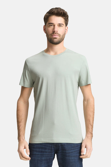 T-shirt vert à manches courtes TOM TAILOR, porté avec un jean bleu foncé et des baskets blanches.