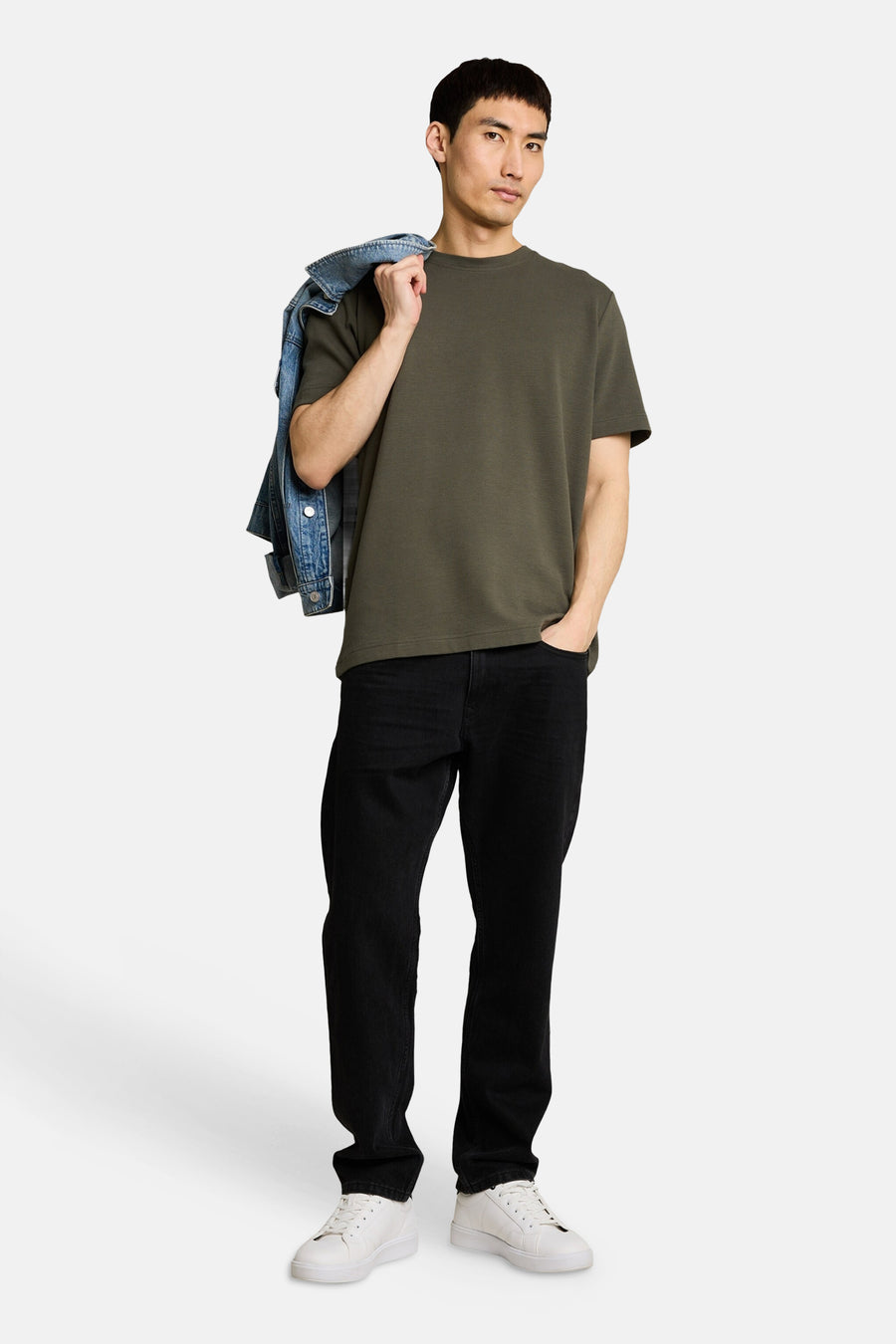 Kaki T-shirt met korte mouwen van TOM TAILOR, met subtiele ribstructuur, gedragen door een man met zwarte jeans en witte sneakers.