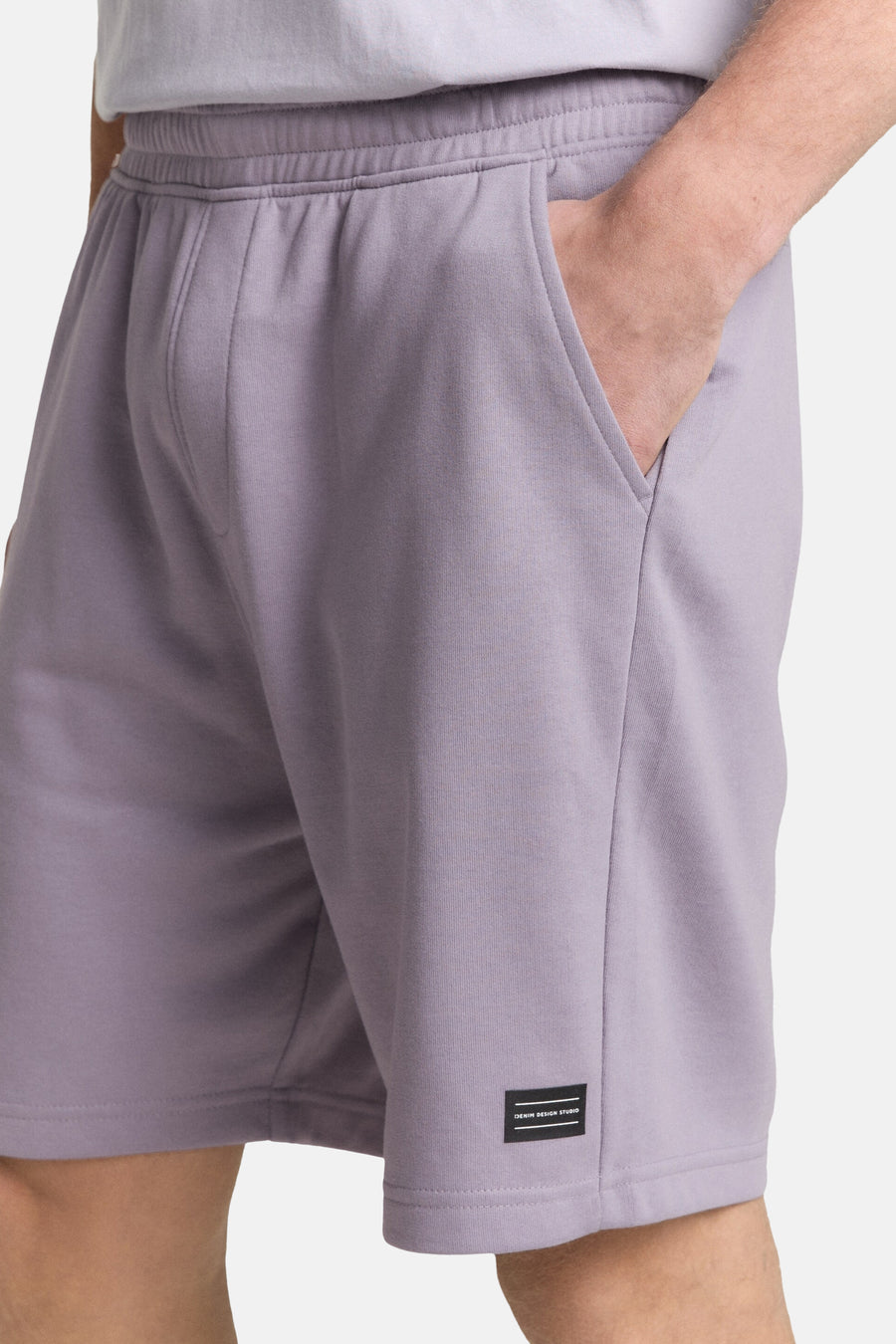 Paarse short van TOM TAILOR, met hand in de zak en logo-label op de zoom.